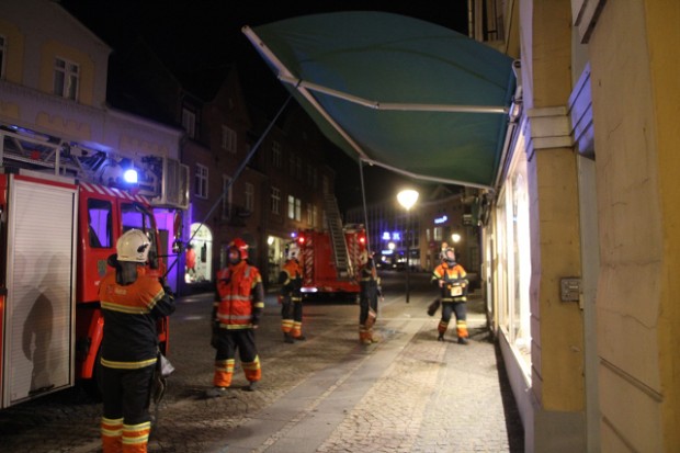 Brandfolk måtte i nattens blæsevejr sikre en markise hos "Lystfiskeren" på Ahlgade. Foto: Morten Sundgaard - Skadestedfotograf.dk.