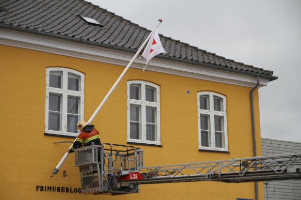 Brandfolk måtte fredag eftermiddag redde flagstangen på Frimurerlogens bygning  på havnen. Foto: Morten Sundgaard - Skadestedsfotograf.dk.