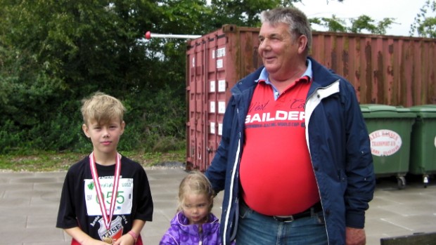 Kun den ene af de tre personer på Billedet deltog i løbet, nemlig den 9-årige Victor Nielsen fra Holbæk, som var på besøg hos farmor og farfar. Viktor ærgrer sig en lille smule over han kun manglede 3 sekunder i at vinde 2 km-løbet for børn, men blev trøstet af farmor. Foto: Jesper von Staffeldt.