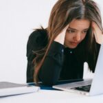 stressed woman looking at a laptop