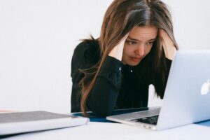 stressed woman looking at a laptop