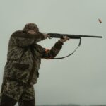 photo of a man firing his shotgun