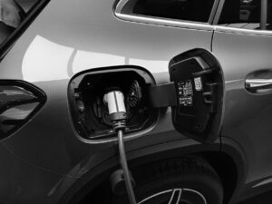 monochrome photo of hybrid car charging