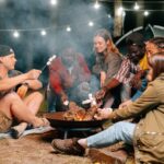 people cooking marshmallows on campfire